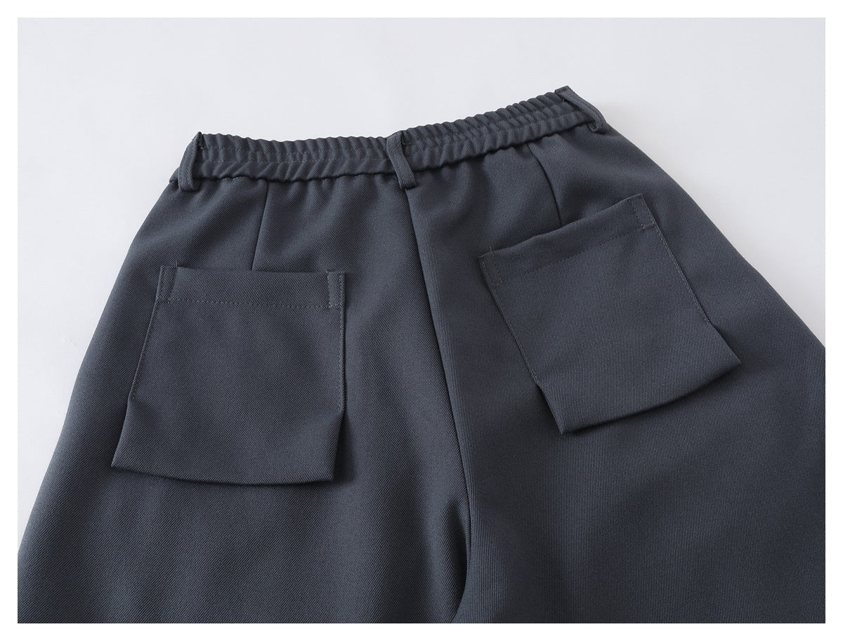 Back view of charcoal trousers laid flat, showing an elastic waistband and two patch pockets.