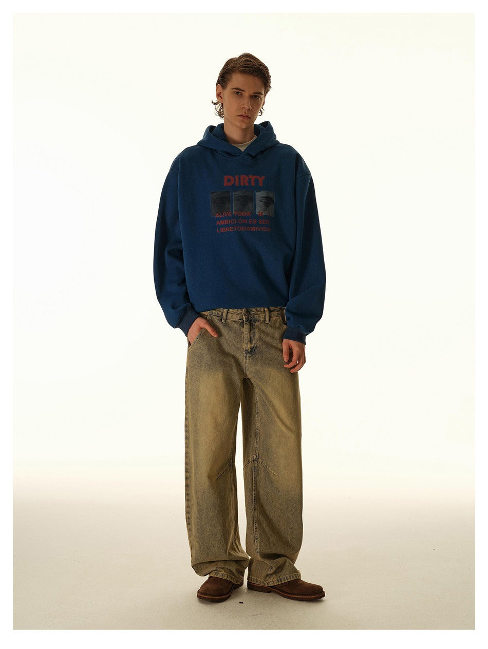 Model wearing faded wide-leg jeans with a blue graphic hoodie and brown shoes, full-length front view