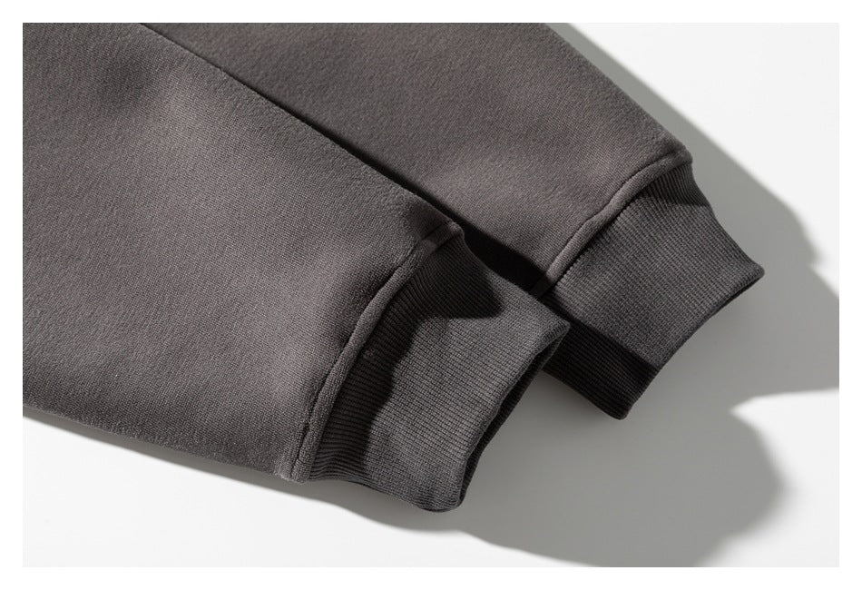Close-up of two charcoal sweatshirt sleeves with ribbed cuffs.