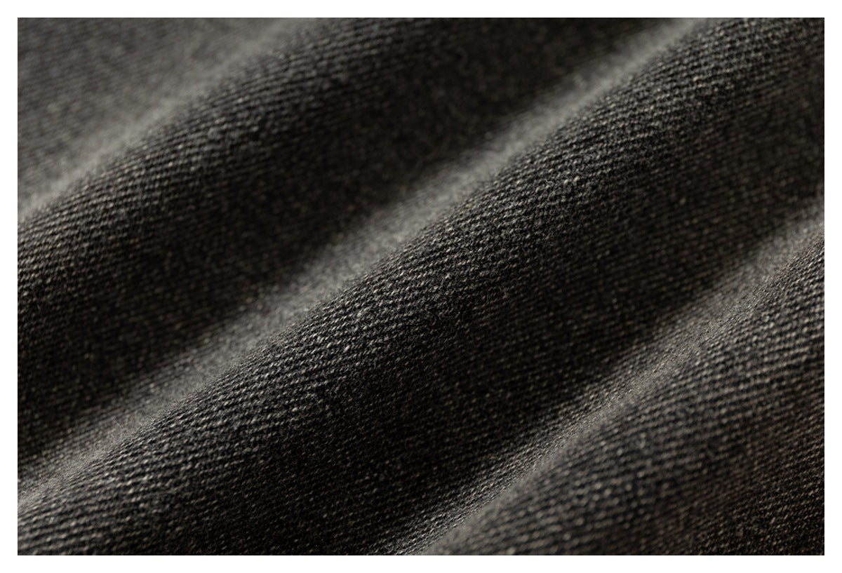 Extreme close-up showing the dark gray woven texture of the pants fabric.