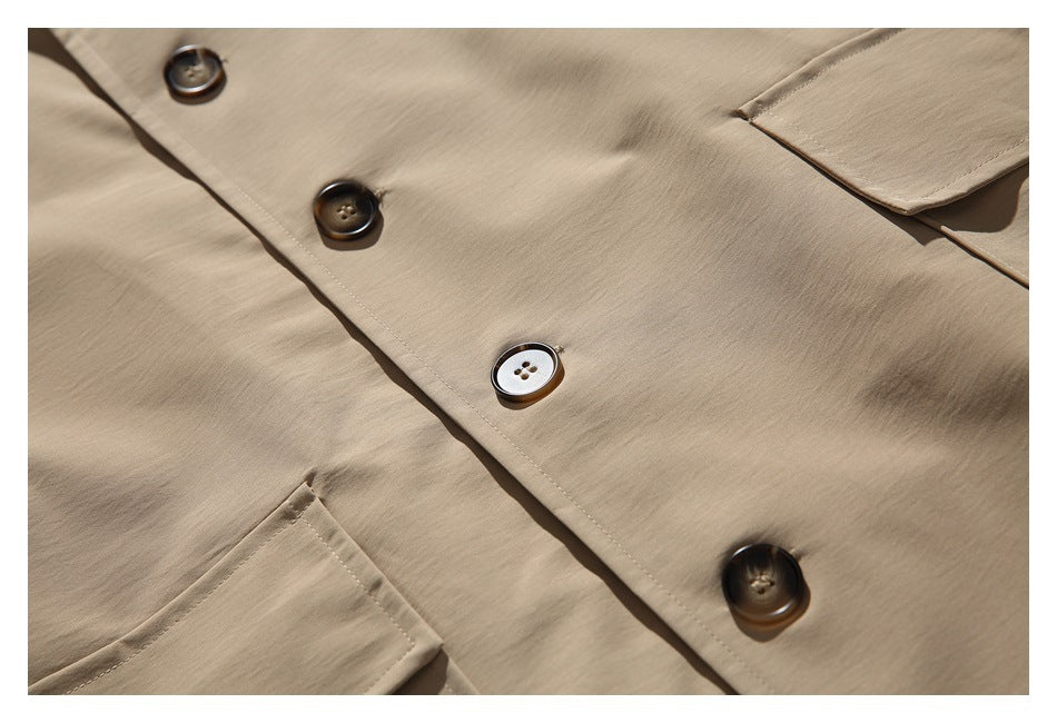 Close-up of the beige coat's button placket, contrasting buttons, and pocket edge.