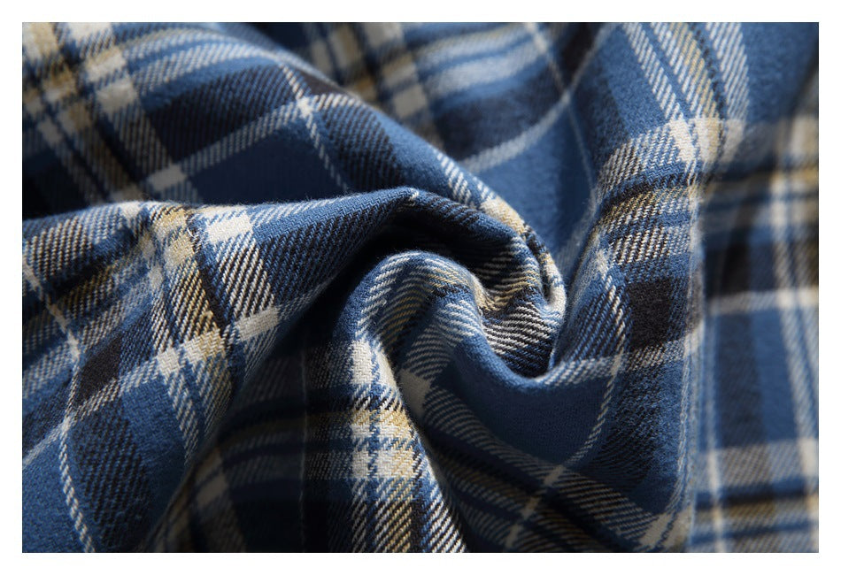 Close-up of blue, navy, and cream plaid fabric gathered into soft folds.
