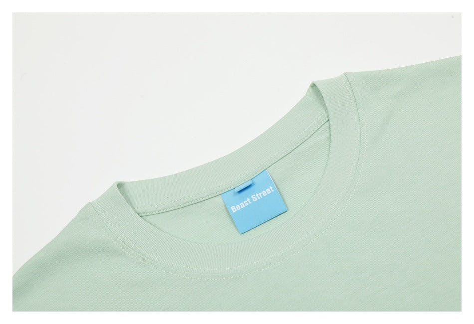 Close-up of a pale mint T-shirt’s crew neck with a blue Beast Street label.