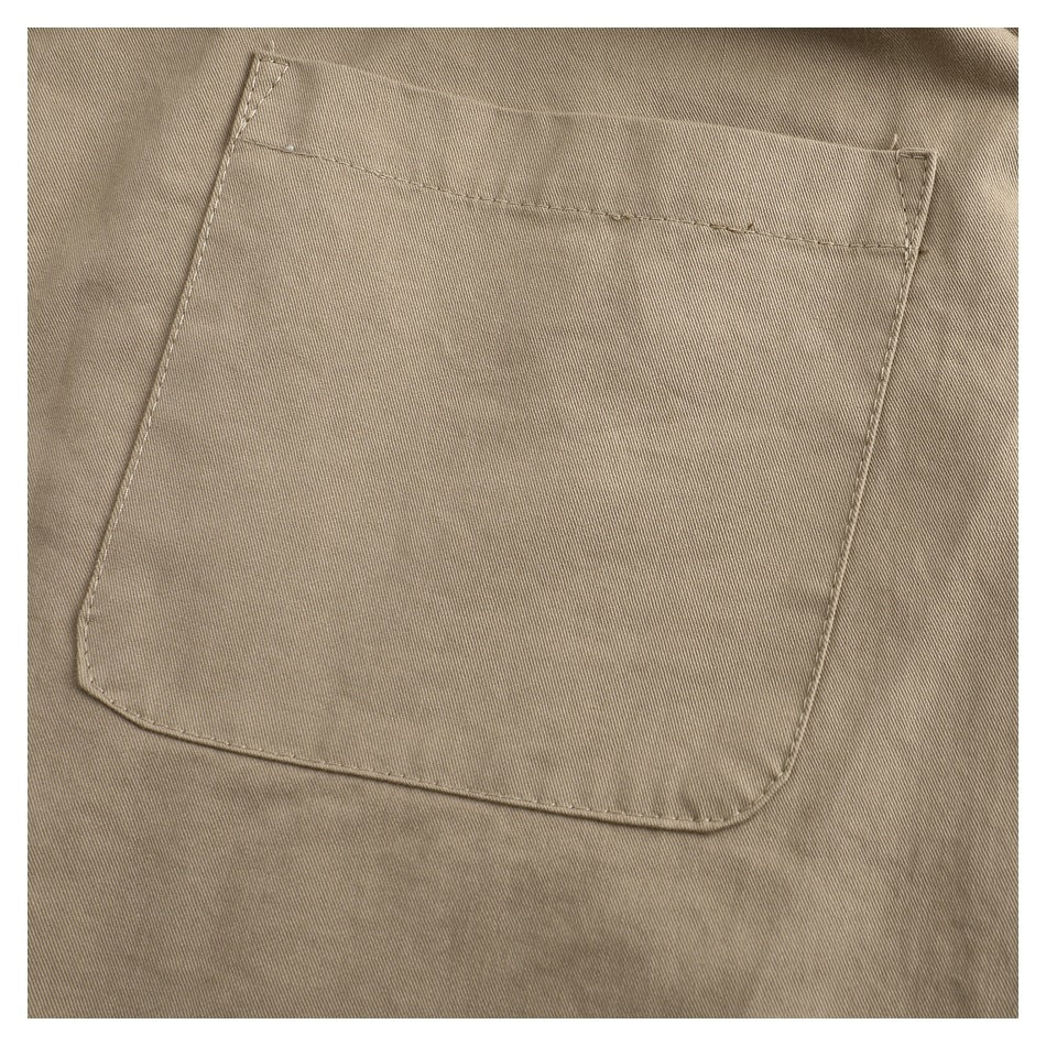 Close-up of a large stitched patch pocket on the back of taupe trousers.