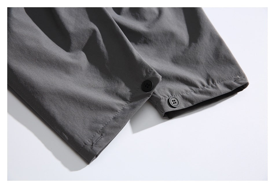 Close-up of a dark gray garment edge with stitching and two black buttons.