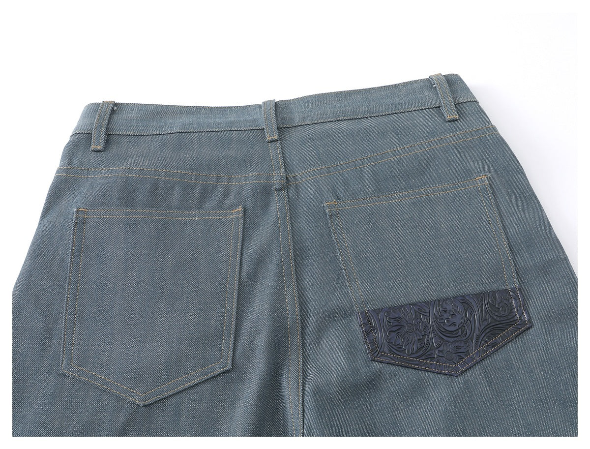 Back view of blue-gray trousers with two patch pockets, one featuring embossed floral trim.