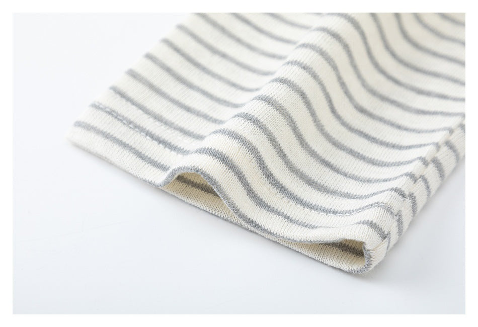 Close-up of a cream-and-gray striped garment edge with a folded, stitched hem.