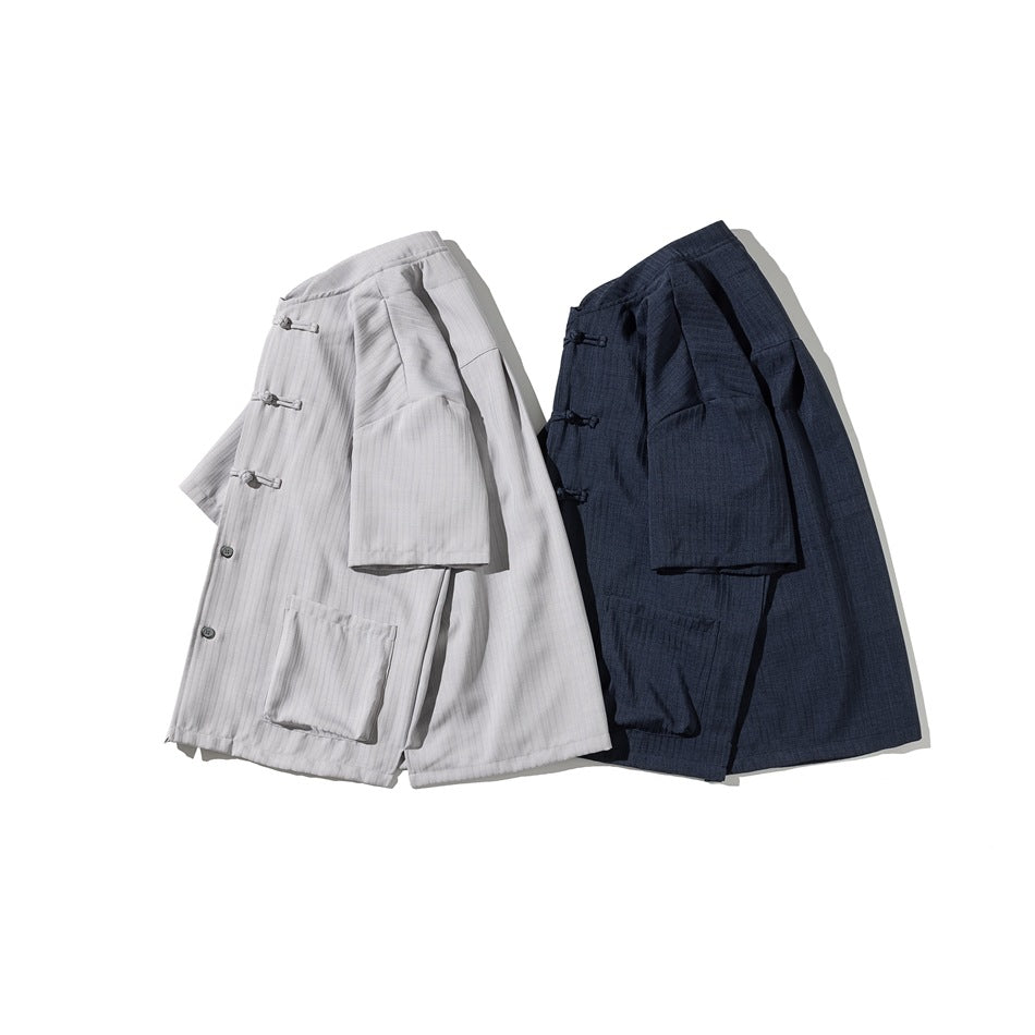 Light gray and navy short-sleeve shirts shown at an angle, with frog closures and front patch pockets.