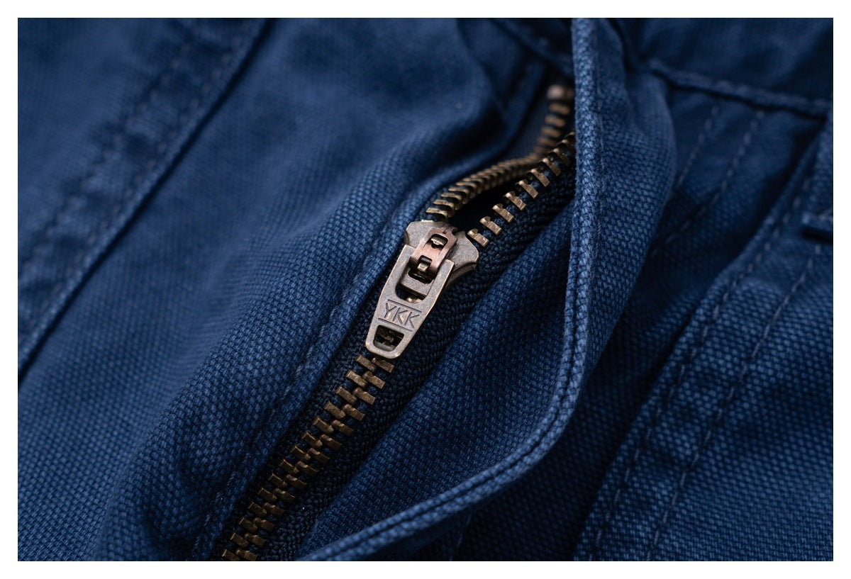 Close-up of a metal zipper and pull on dark blue trousers.