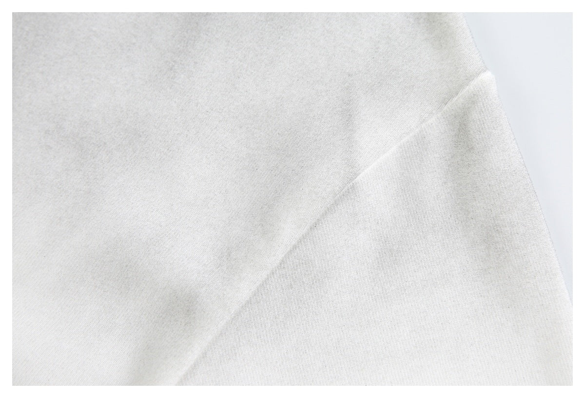 Close-up of the off-white shirt's sleeve and shoulder seam.