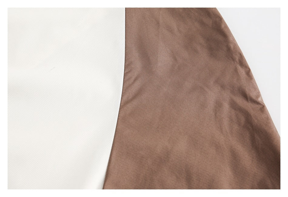 Close-up of adjoining off-white and brown grid-patterned garment panels.