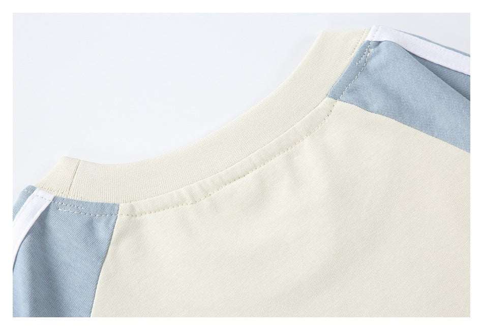 Close-up of a cream neckline and shoulder with pale blue panels and white trim.