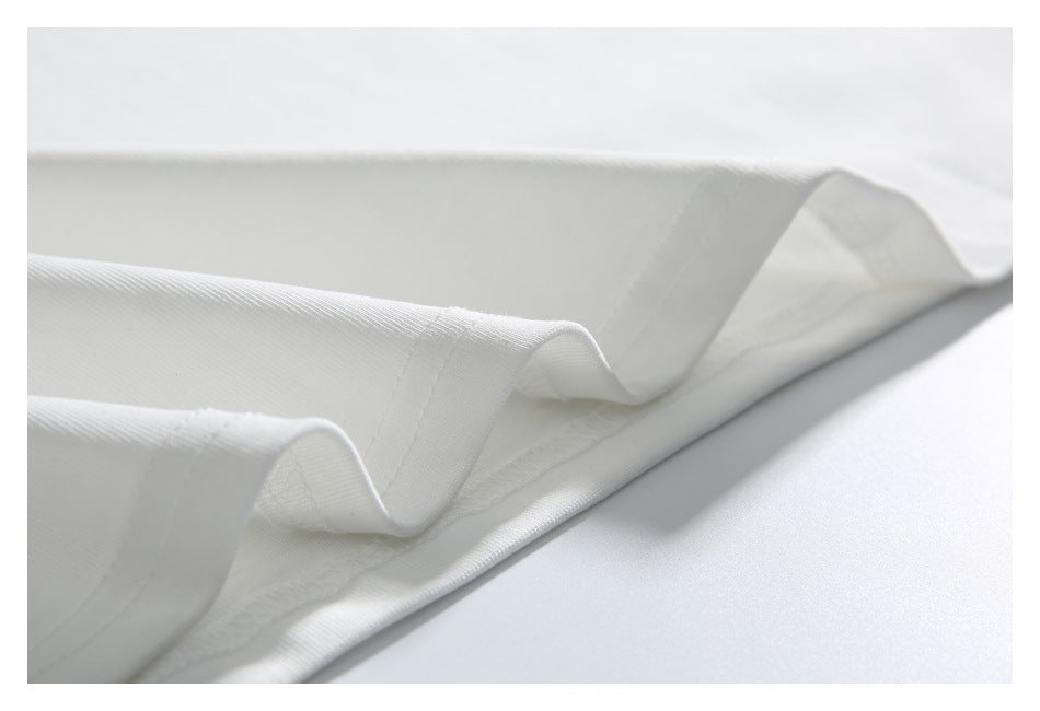 Close-up of a white garment hem with folded, stitched edges.