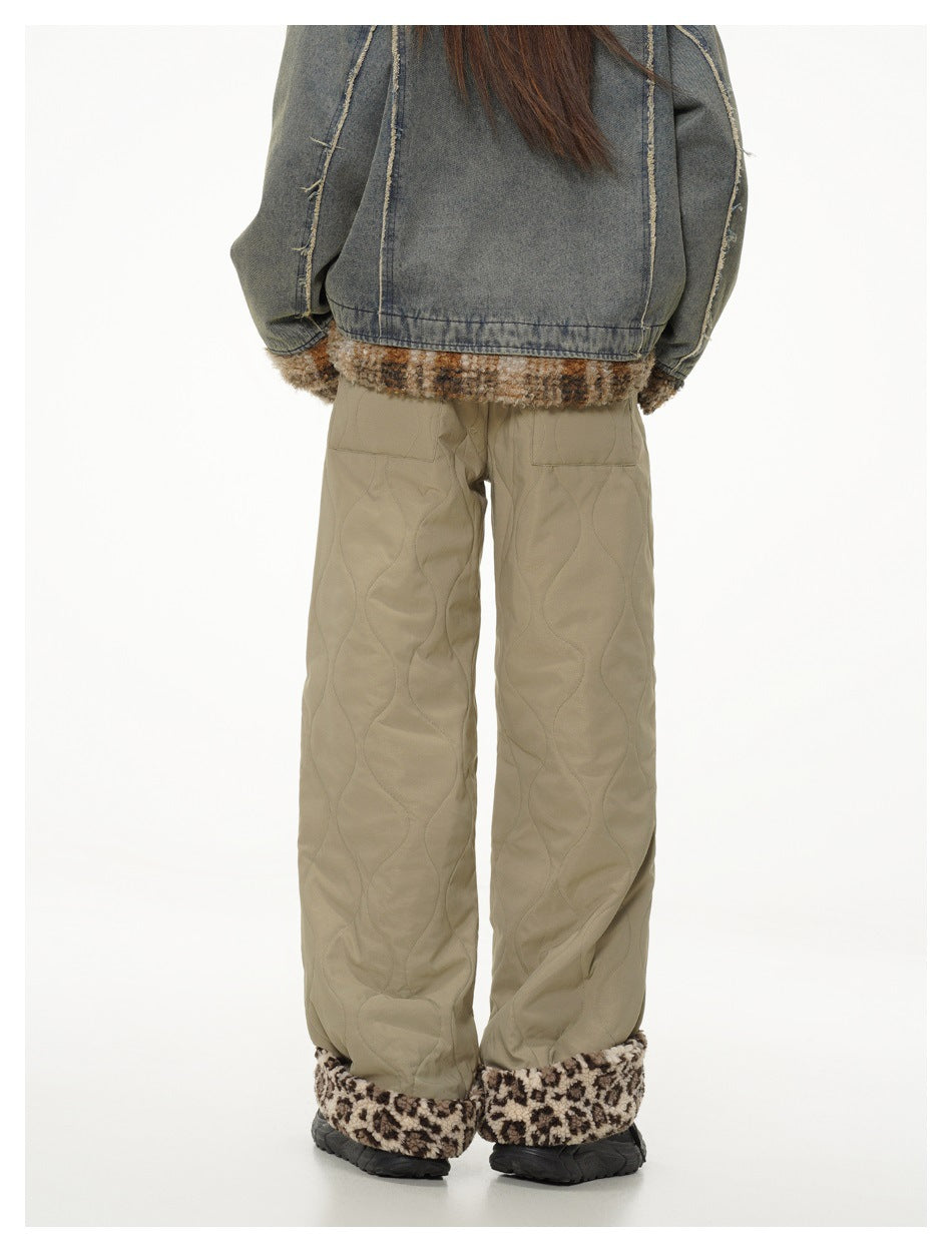 Rear view of a model wearing khaki quilted wide-leg pants with brown patterned fleece cuffs.