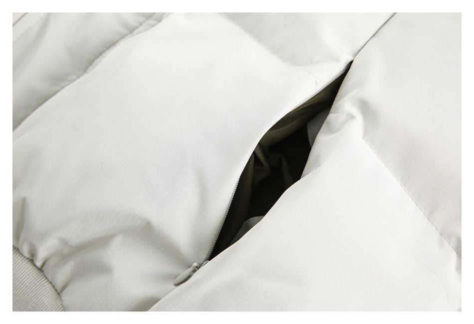 Close-up of a partly open zip pocket on a white jacket.