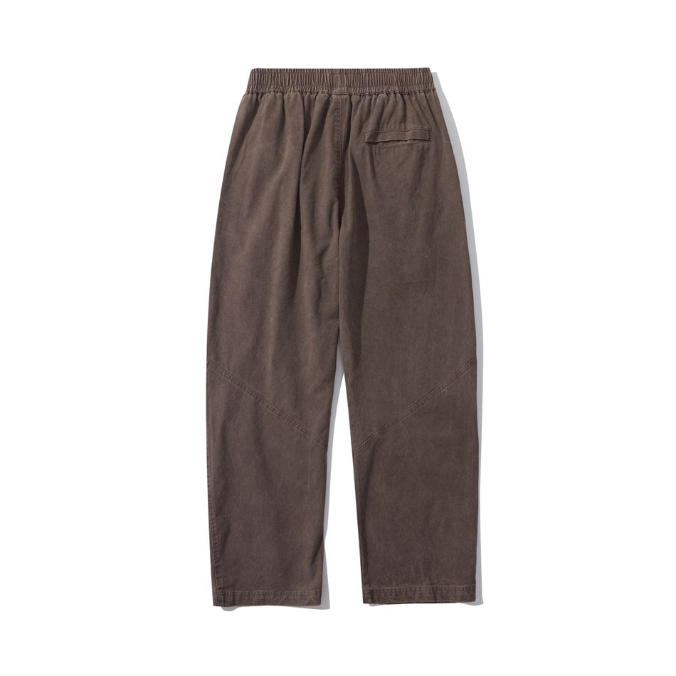 Brown straight-leg pants, flat back view with elastic waistband, flap back pocket and diagonal seams