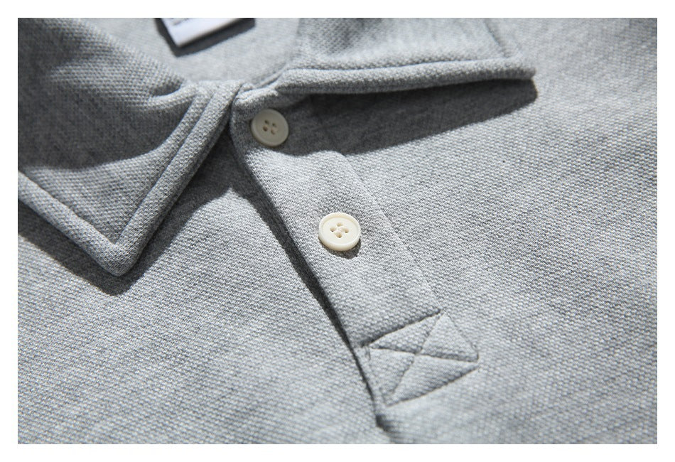 Close-up of the gray pullover's collar and placket, showing two light buttons and reinforced stitching.