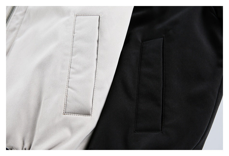 Close-up of light gray and black bomber jackets showing the rectangular sleeve pocket details.