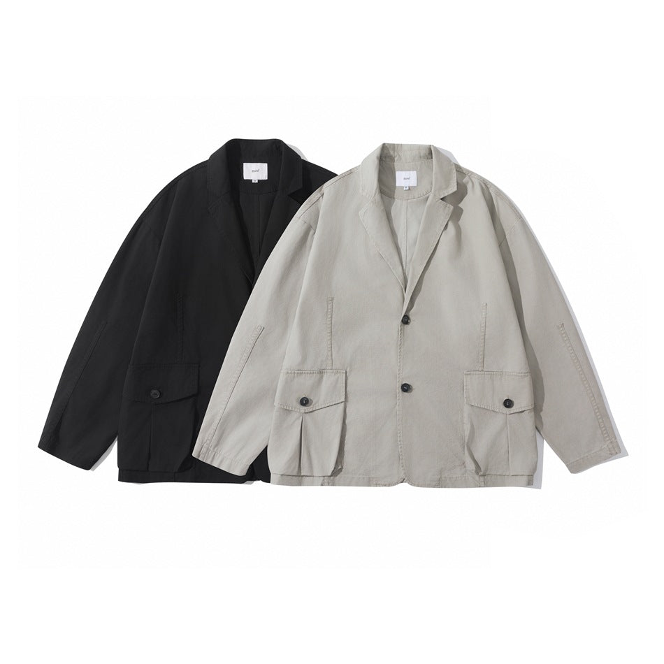 Two jackets shown from the front: one black and one light gray-beige, with notched collars and buttoned flap pockets.