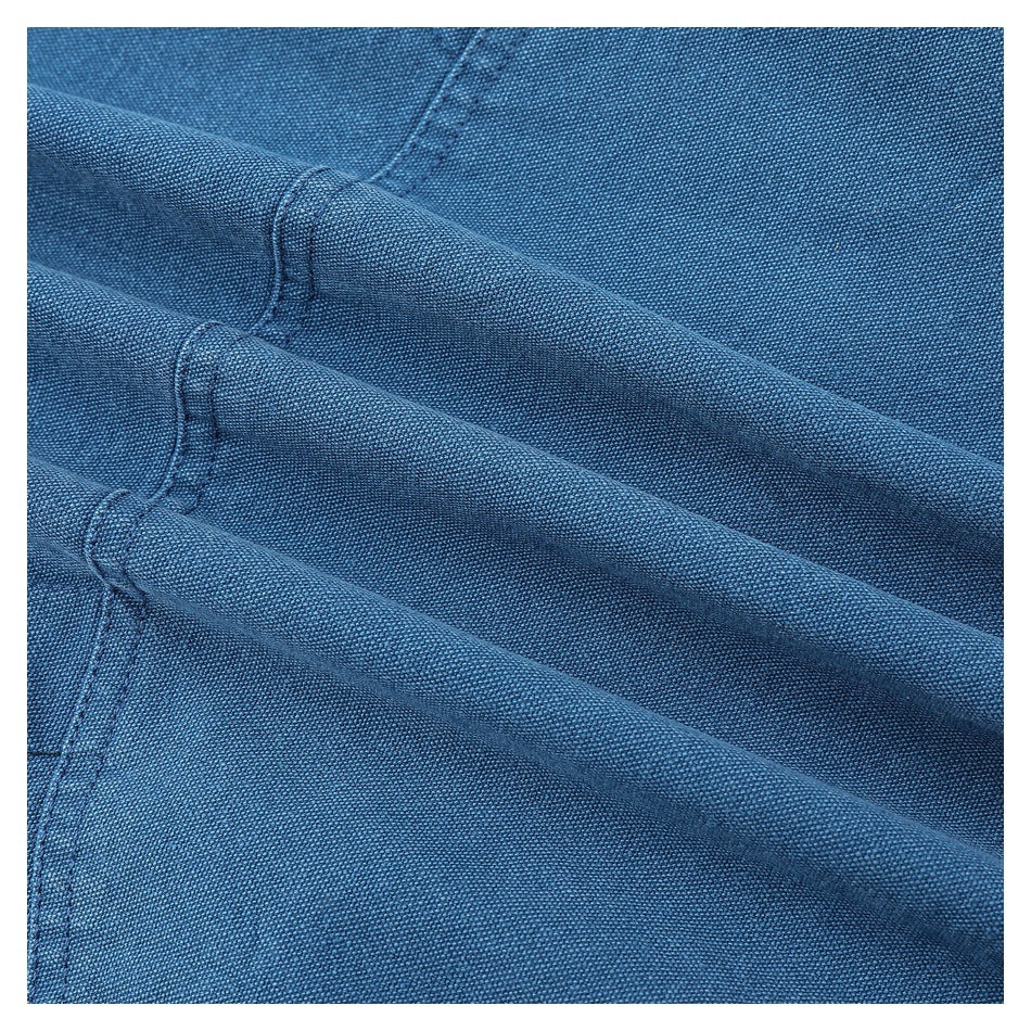 Close-up of blue woven fabric arranged in soft folds, showing its texture and stitching.