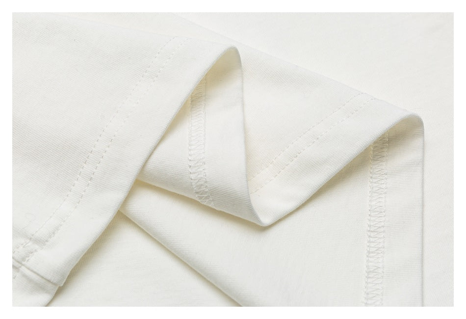 Close-up of folded off-white fabric showing seam stitching and an overlocked edge.