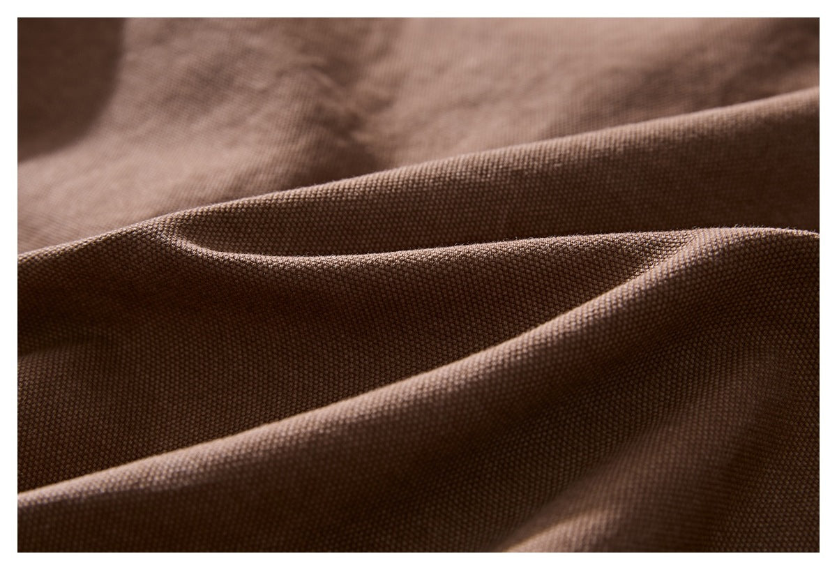 Close-up of brown textured fabric draped in soft folds.