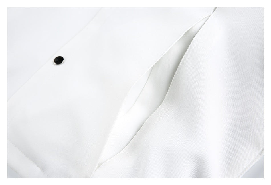Close-up of white garment fabric with a dark snap button and a long folded seam or pleat.