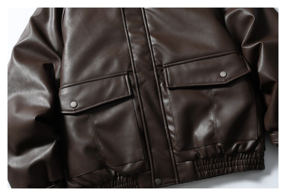 Close-up of the dark brown jacket's front flap pockets, snap fasteners, and gathered hem.