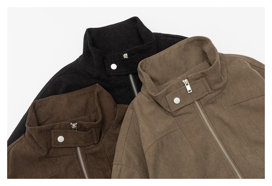 Close-up of black and brown zip-up jackets showing their stand collars, snap tabs, and metal zippers.