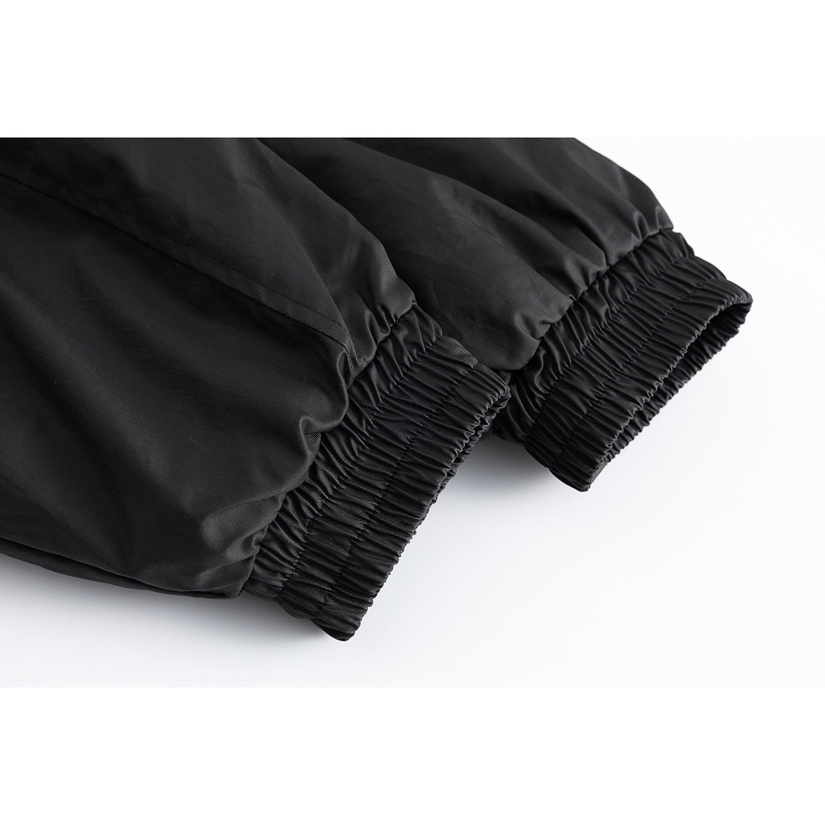 Close-up of black jacket sleeves with gathered elastic cuffs.