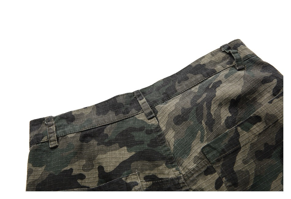 Close-up of camouflage trousers showing the waistband, belt loops and pocket seam.