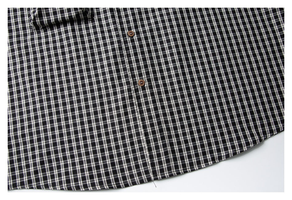 Flat-lay view of the lower front of a black-and-white checked button-up shirt.