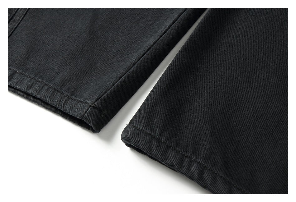 Close-up of two black trouser hems with visible stitching on a white background.