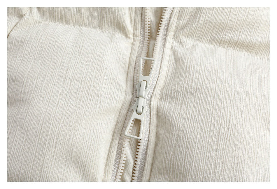 Close-up of the ivory jacket's center zipper and textured fabric.