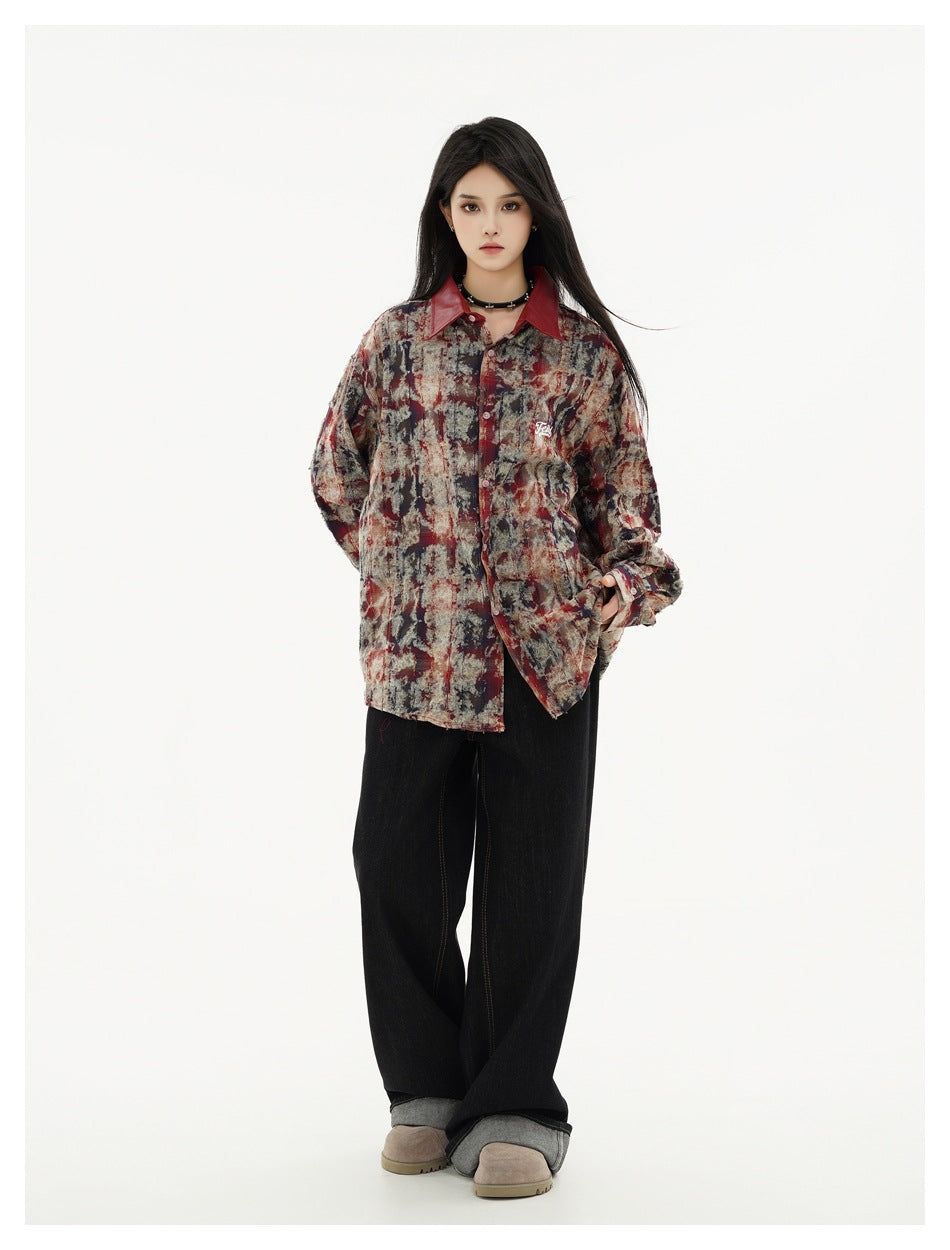 Full-length model wearing a burgundy, charcoal, and beige abstract-print shirt with black wide-leg trousers.