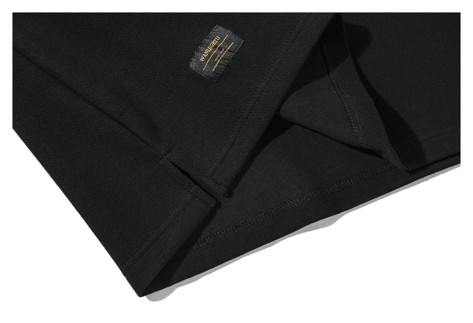 Close-up of the inside hem stitching and sewn label on a black shirt.
