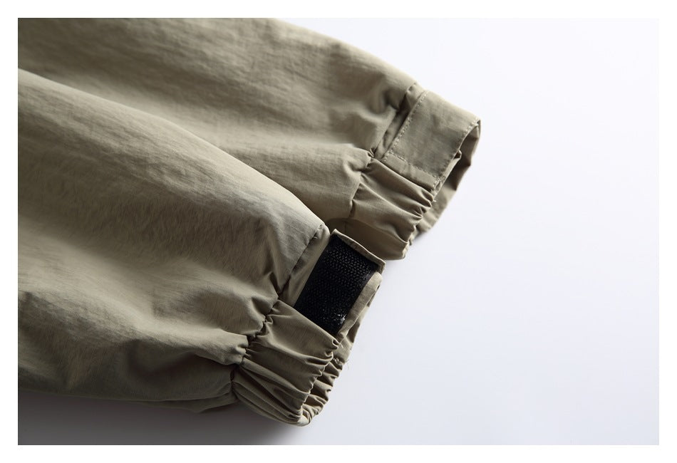 Close-up of the jacket cuff with gathered fabric and a hook-and-loop adjustment tab.
