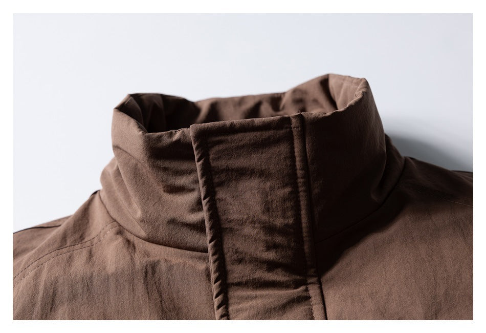 Close-up of a brown jacket's tall stand collar and covered front placket.