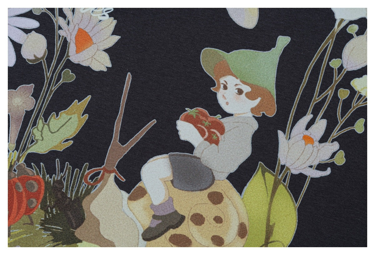 Close-up of a colorful child-and-flowers illustration printed on charcoal fabric.