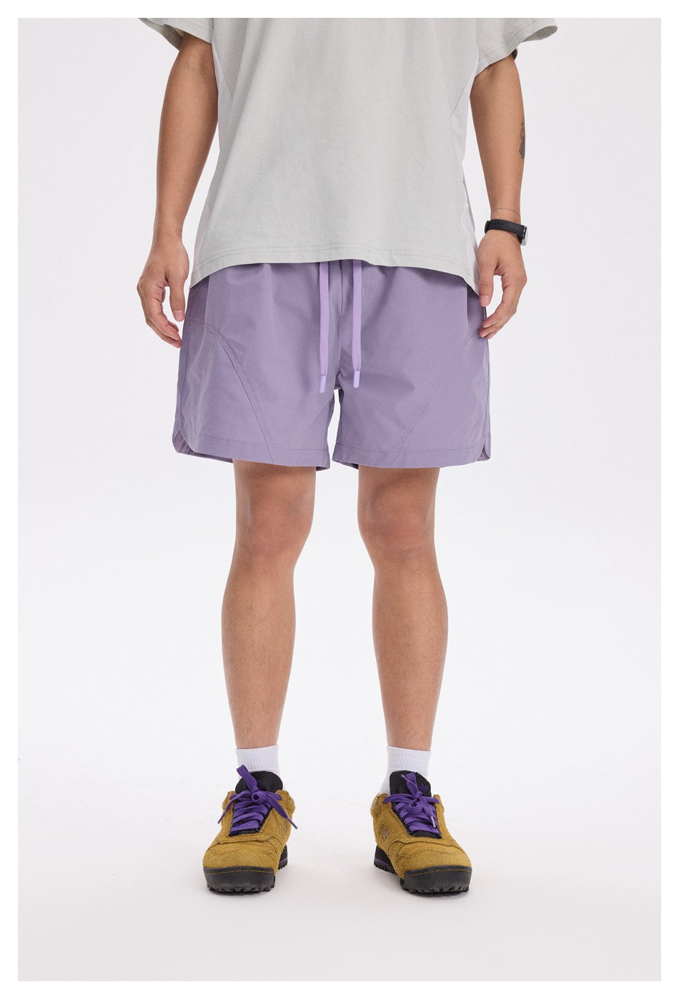 Front view of a person wearing lavender shorts with a drawstring waist and curved pocket seams.