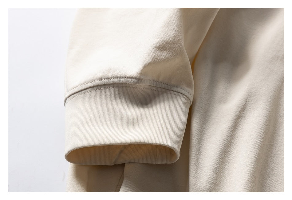 Close-up of a cream sweatshirt sleeve ending in a wide ribbed cuff.
