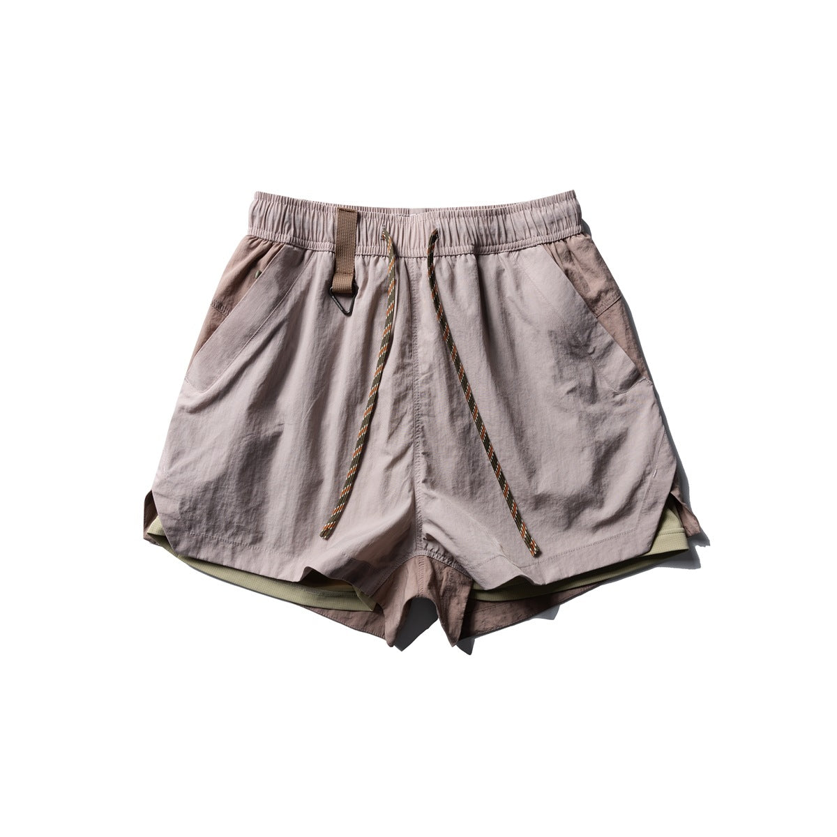 Flat-lay front of dusty pink shorts with elastic waist, braided drawstring, side pockets and olive inner layer