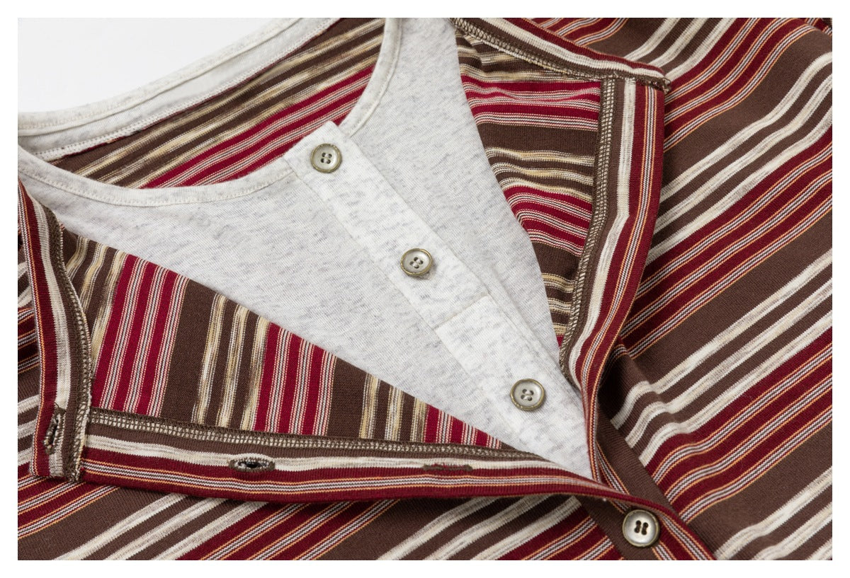 Close-up of a brown, burgundy, and cream striped top with a light gray button placket and contrasting inner layer.
