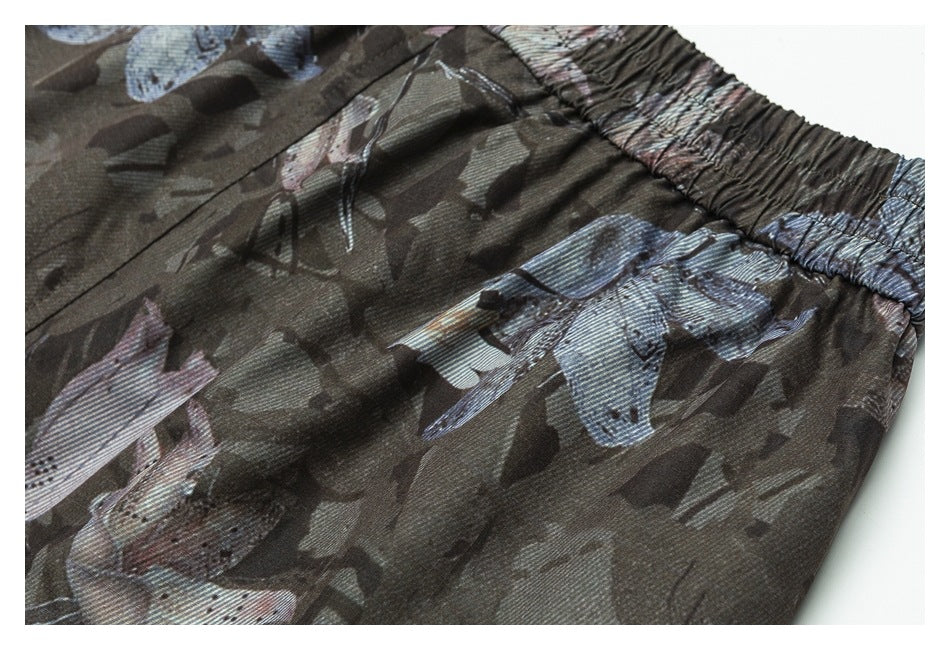 Close-up of dark olive printed garment with an elasticated waistband and muted blue, pink and gray motifs.