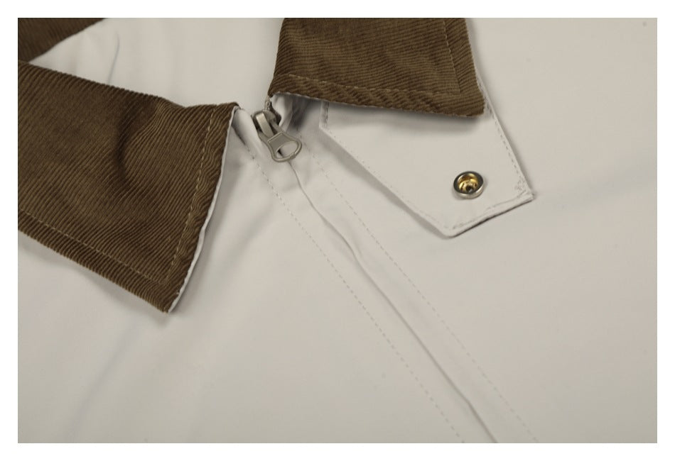 Close-up of the brown corduroy collar, metal zipper pull, and snap-fastened ivory jacket placket.