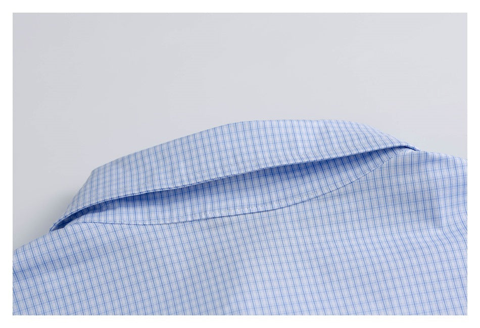 Close-up of the collar on a light blue fine-check shirt.