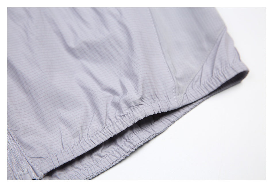 Close-up of the light gray jacket's gathered elastic hem and stitched edge.