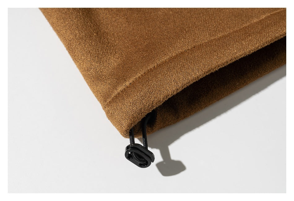 Close-up of the camel-brown coat hem with a black cord and toggle adjuster.