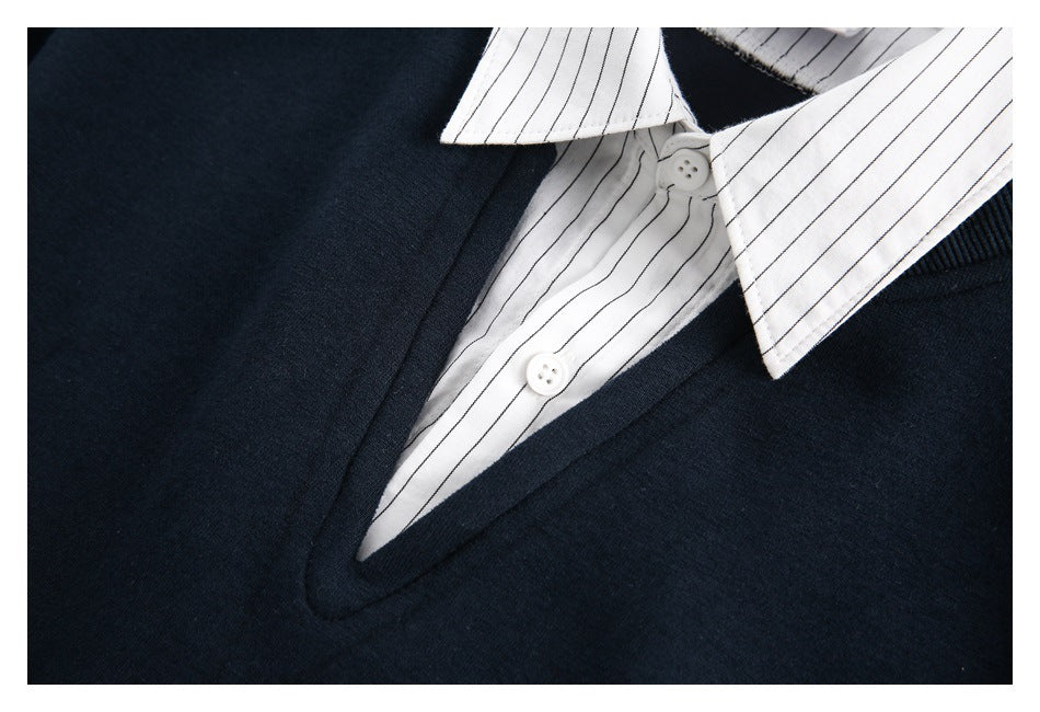 Close-up of the navy V-neckline, white striped shirt collar, and two white buttons.