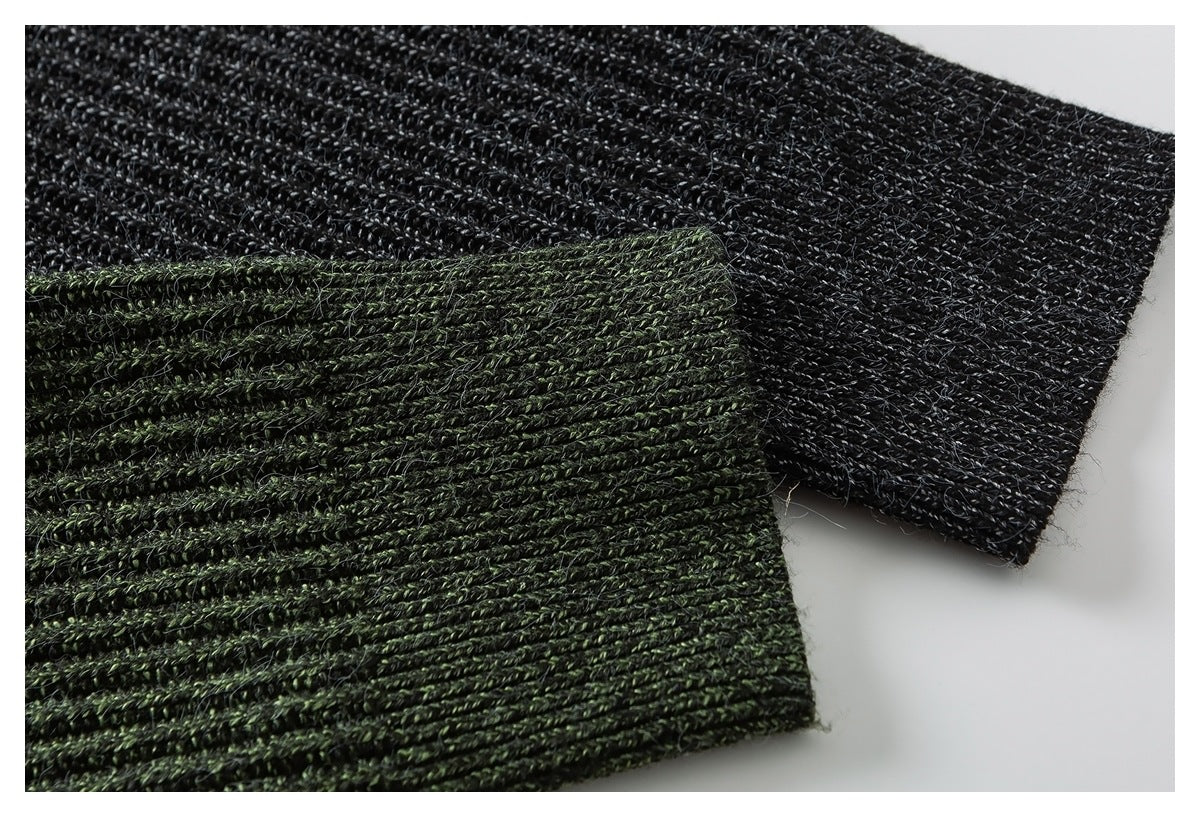 Close-up of dark charcoal and deep green knitted garment sections with ribbed, twisted yarn texture.